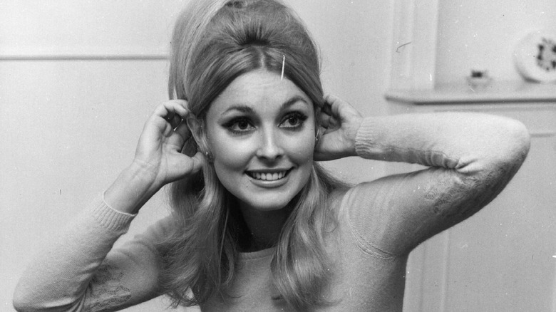 Sharon Tate smiling, adjusting hair