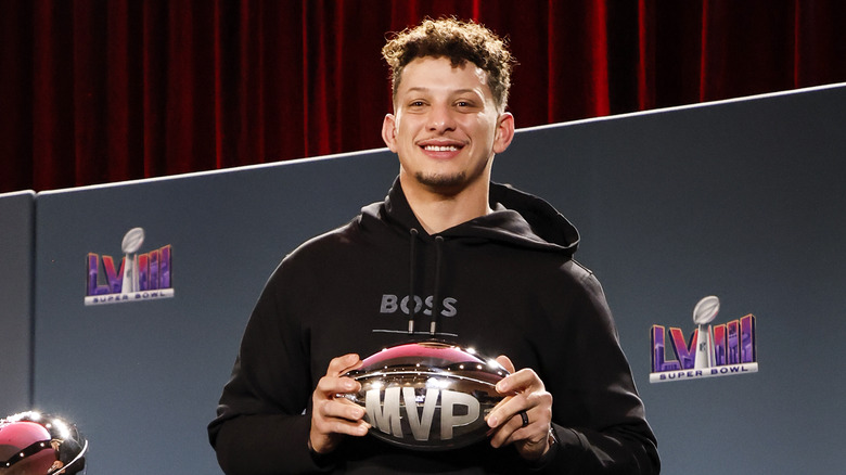 Patrick Mahomes smiling with metallic "MVP" football