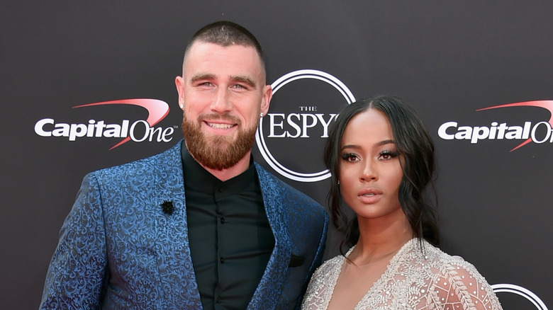 Travis Kelce and Kayla Nicole stand at red carpet event