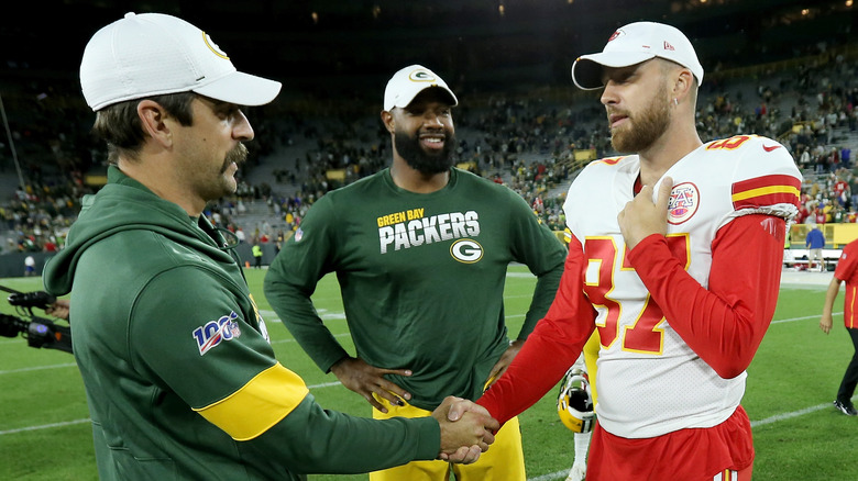 Travis Kelce and Aaron Rodgers shake hands on football field