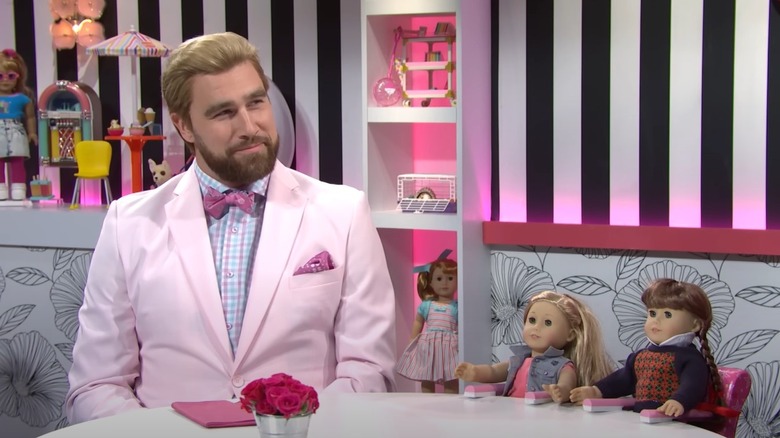 Travis Kelce at table with dolls