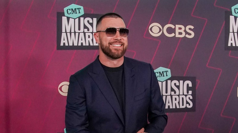 Travis Kelce dark blue suit sunglasses