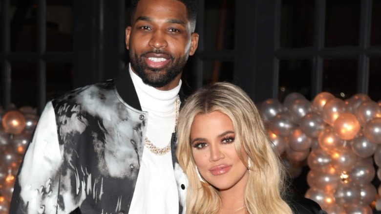 Tristan and Khloe smile in front of balloons