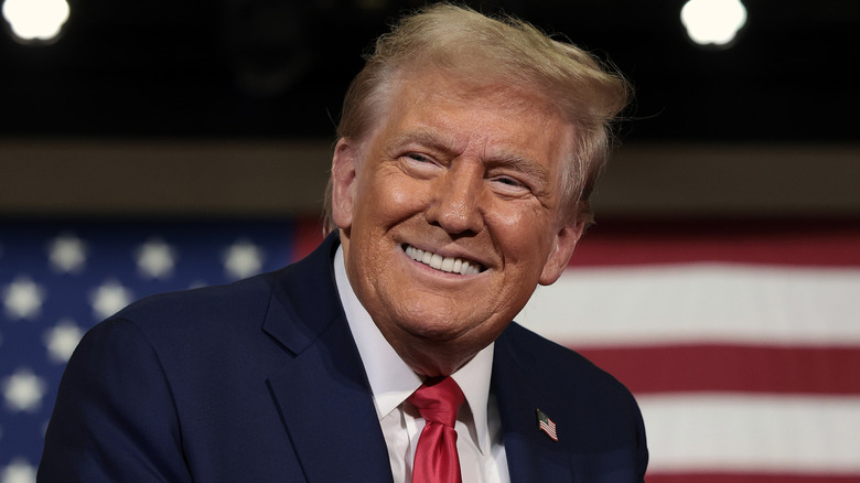 Donald Trump standing in front of a flag