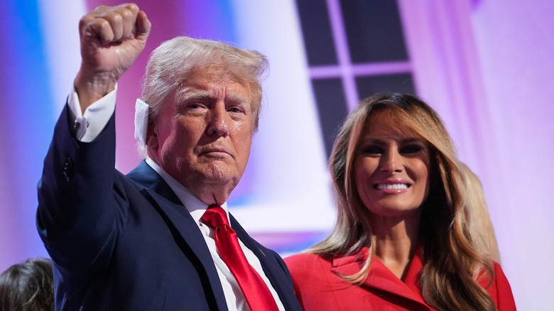 Donald Trump with raised fist, Melania Trump smiling