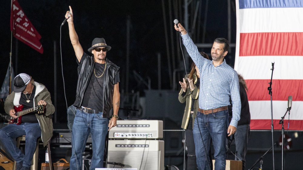 Kid Rock and Donald Trump, Jr. holding their hands in the air onstage