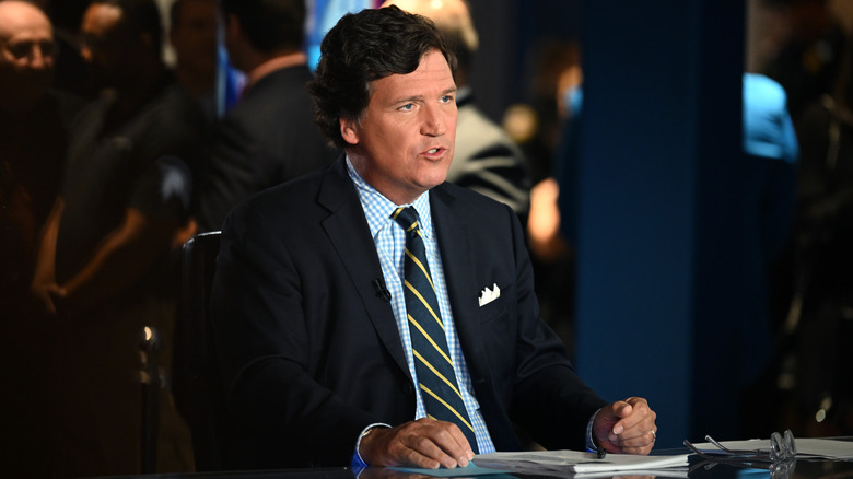 Tucker Carlson at a desk