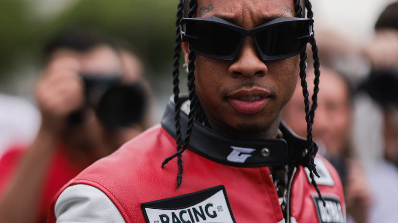 Tyga in shades and car racing jacket