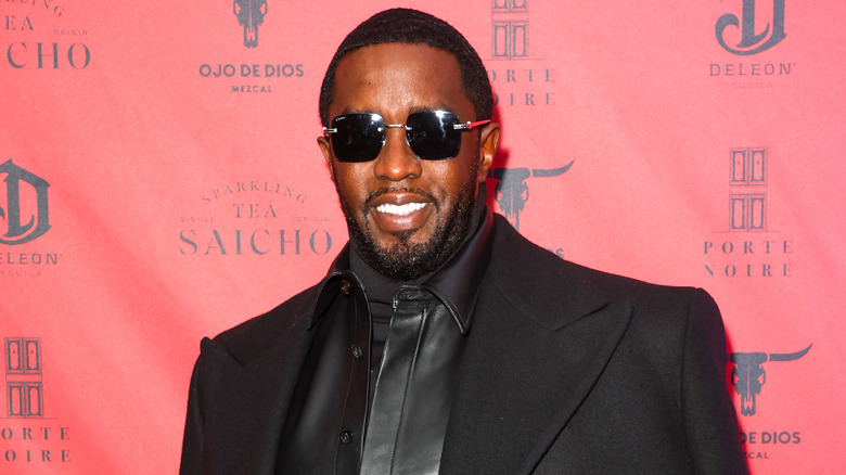 Diddy wearing an all-black outfit and sunglasses with black lenses