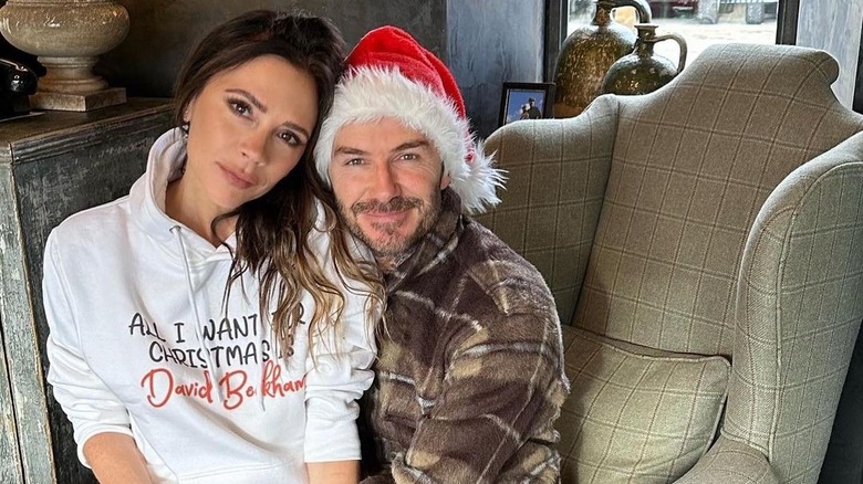 Victoria Beckham sitting on David Beckham's lap