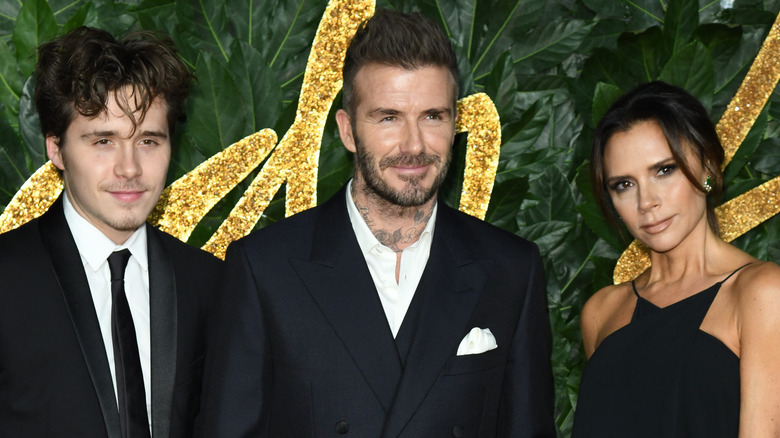 Brooklyn Beckham with parents at an event 