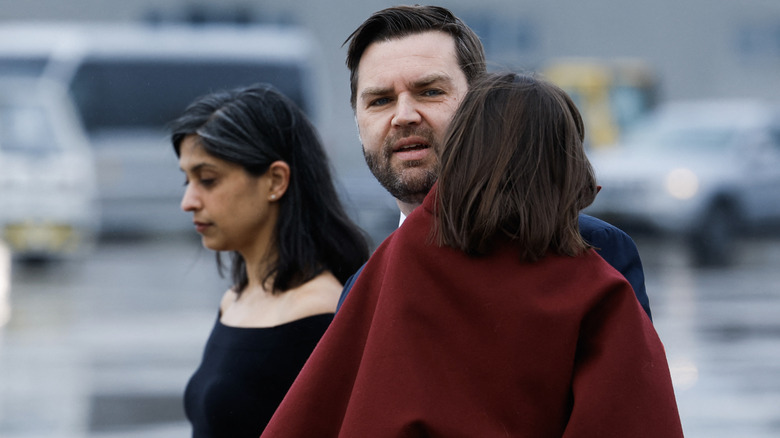 Usha Vance walking with JD Vance carrying daughter Mirabel