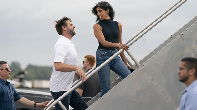 Usha Vance looking back at JD Vance as they board plane