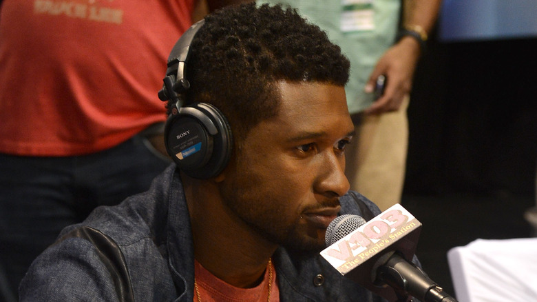 Usher sitting in front of a microphone