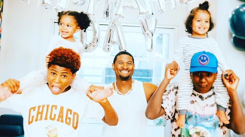 Usher posing with his four kids