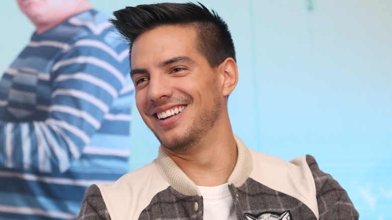 Vadhir Derbez smiling in grey and white jacket