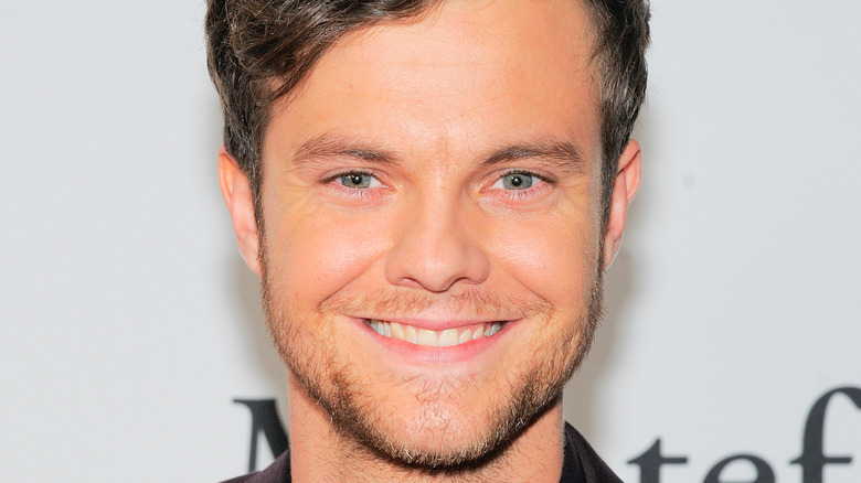 Jack Quaid smiles on the red carpet