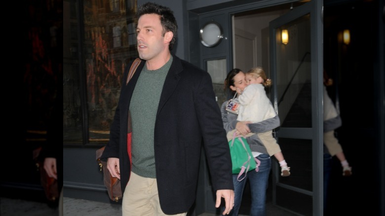 Ben Affleck walking while Jennifer Garner carries Violet