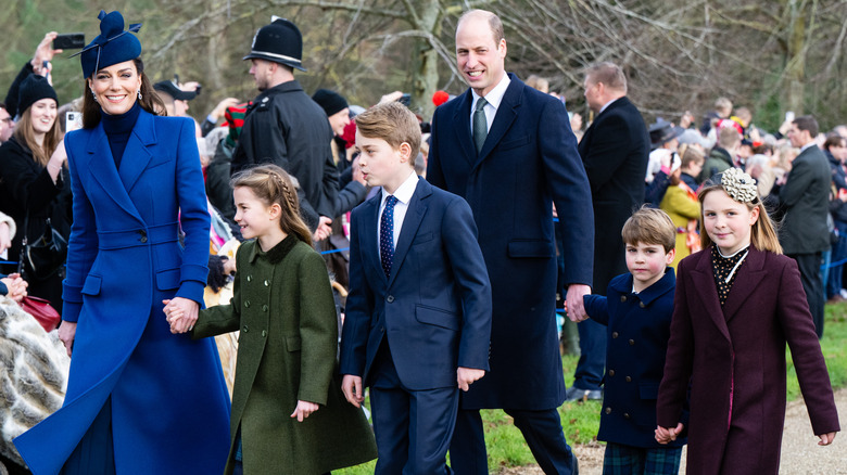 Kate Middleton, Prince William, and their children walking in park