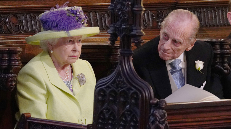 Queen Elizabeth in yellow hat with Prince Philip