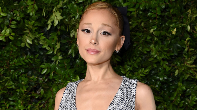 Ariana Grande posing against foliage at the Academy Women's Luncheon