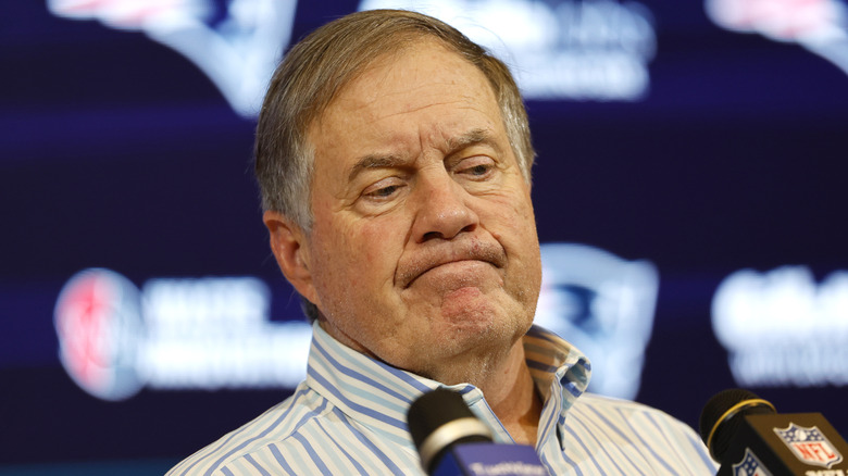 Bill Belichick frowning at microphones