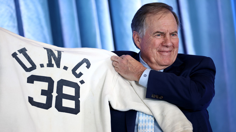 Bill Bilicheck holding up a UNC sweater