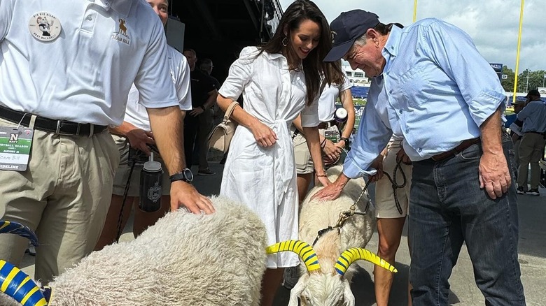 Jordon Hudson and Bill Bilicheck petting a goat