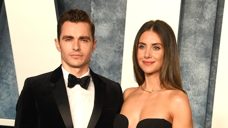 Dave Franco with a serious face, Alison Brie smiling at the Vanity Fair Oscars party