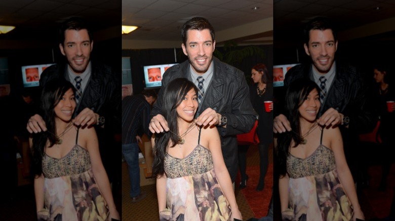 Drew Scott poses behind Linda Phan with his hands on her shoulders