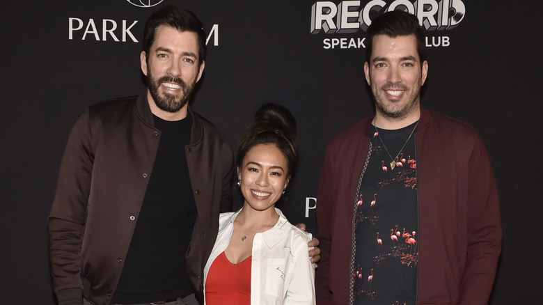 Linda Phan poses between Drew and Jonathan Scott in 2019