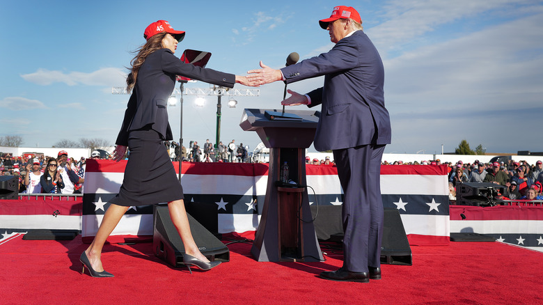 Kristi Noem shaking Donald Trump's hand at rally