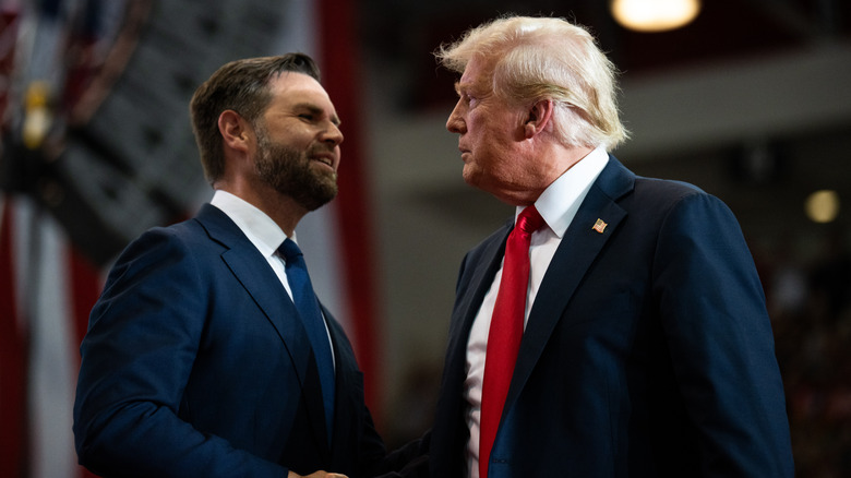 JD Vance and Donald Trump shaking hands at a rally in Minnesota