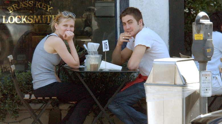 Kirsten Dunst and Jake Gyllenhaal sitting outdoors