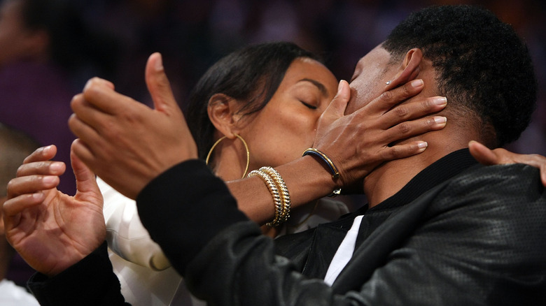 Jada Pinkett Smith and Will Smith sharing a kiss at a 2008 NBA playoff game