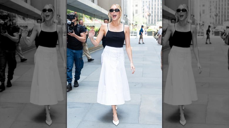 Alex Cooper walking in streets wearing sunglasses with her mouth open