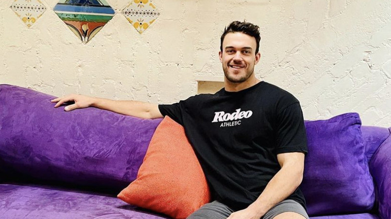 Ben Smith smiling on a purple couch