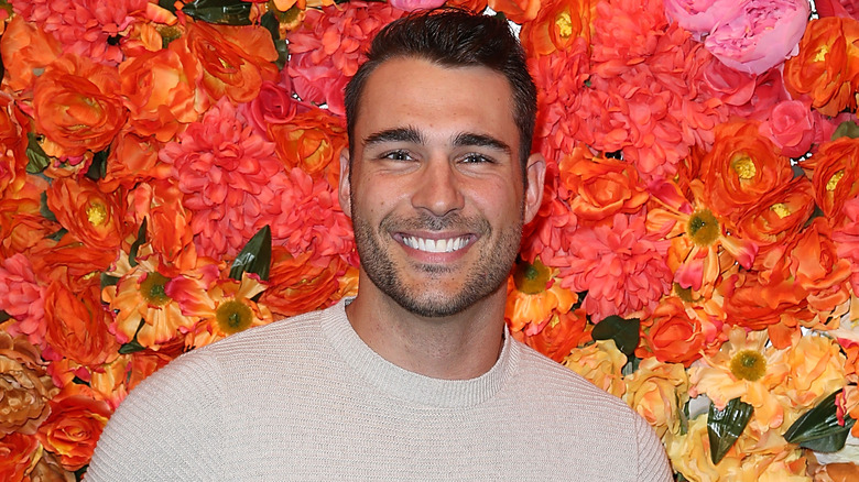 Ben Zorn posing in front of flowers