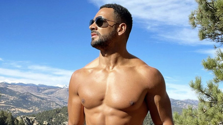 Clay Harbor posing shirtless on a hike