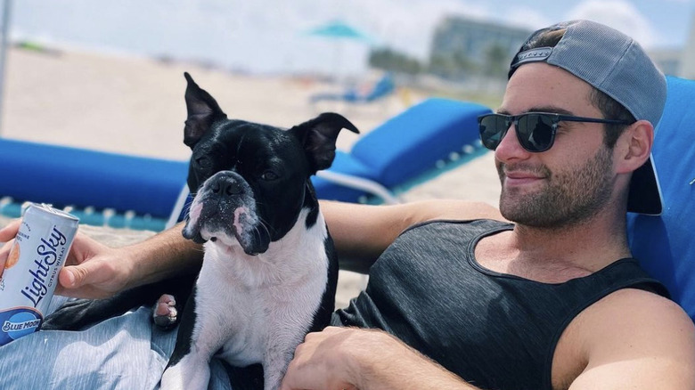 David Ravitz suntanning with a dog on his lap