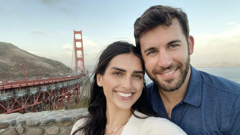 Derek Peth and Saffron Vadher smiling in front of the Golden Gate bridge