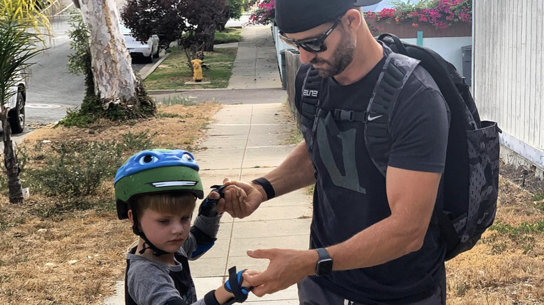 Kiptyn Locke teaching his son to skateboard