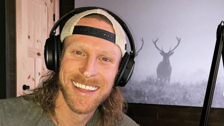 Kirk DeWindt wearing earphones and podcasting