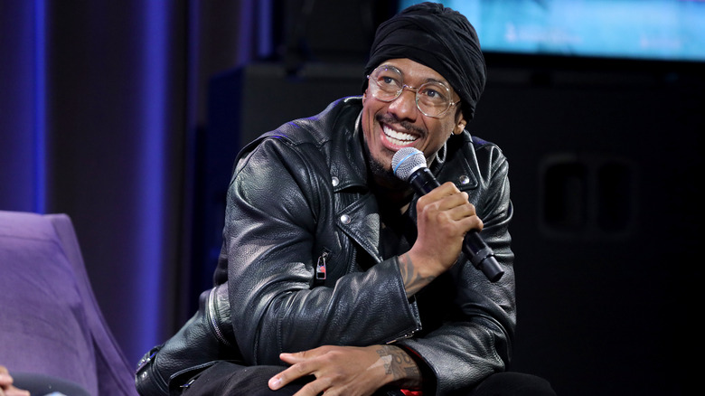 Nick Cannon holding microphone, seated