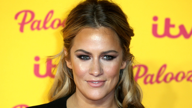 Caroline Flack posing in front of yellow background