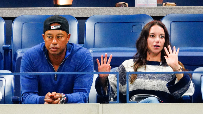 Tiger Woods and Erica Herman, sitting at the stands