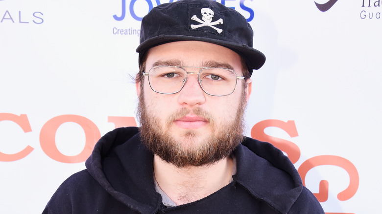  Angus T. Jones wearing hat with beard and serious expression in 2016