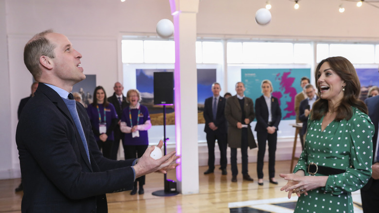 Prince William juggles as wife Kate looks on