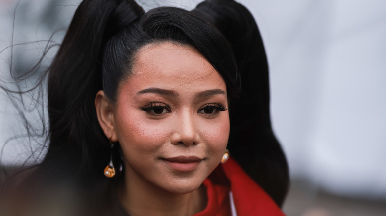 Bella Poarch poses on the red carpet in a red jacket