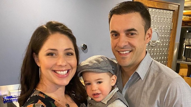 Chelsea and Dan Gheesling posing with one son